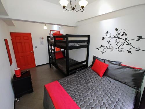 a bedroom with a bunk bed and a red door at Cayalito Apart Hotel in Guatemala