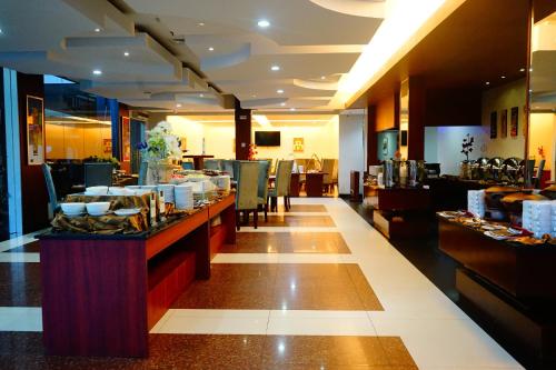 a restaurant with a buffet line with plates of food at Grand Hatika Hotel in Tanjungpandan