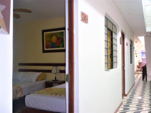 a bedroom with a bed and a room with a door at Anccalla Inn Guesthouse in Nazca