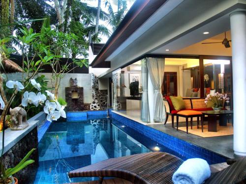 a hotel room with a pool table and chairs at Royal Kamuela Villas & Suites at Monkey Forest Ubud in Ubud