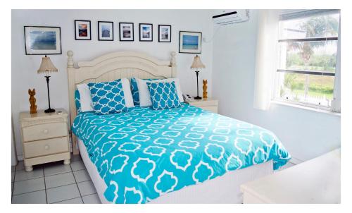 um quarto com uma cama com um edredão azul e branco em Beauport One-Bedroom Apartment em Freeport