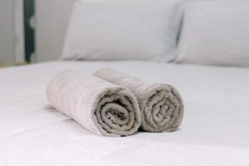 a pile of towels sitting on a bed at TheDaun Homestay Seri Iskandar, Perak in Seri Iskandar