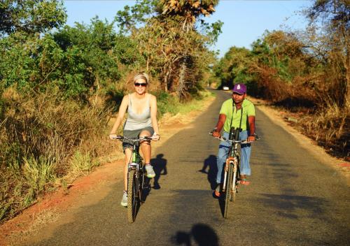 un hombre y una mujer montando bicicletas por un camino en Back of Beyond - Pidurangala en Sigiriya
