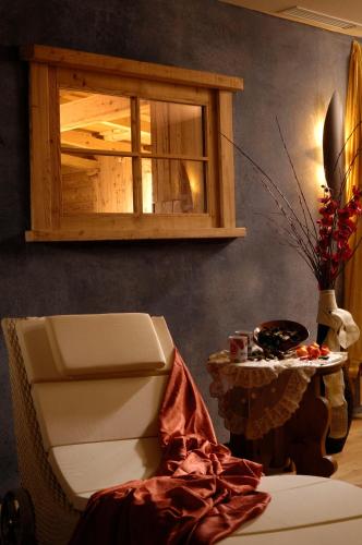 a room with a chair and a window and a table at Tevini Dolomites Charming Hotel in Commezzadura