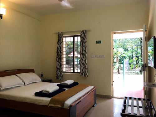 a bedroom with a bed and a large window at Palm Grove Service Villa in Cochin