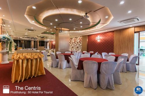 a banquet hall with red and white tables and chairs at The Centris Hotel Phatthalung in Phatthalung