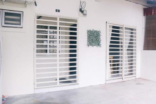 a white house with a door and windows at TheDaun Homestay Seri Iskandar, Perak in Seri Iskandar