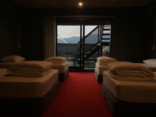 een kamer met 4 bedden en een groot raam bij 248 STREET HOSTEL in Chiang Mai