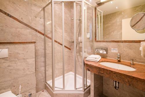 uma casa de banho com um chuveiro e um lavatório. em Best Western City Hotel Braunschweig em Braunschweig