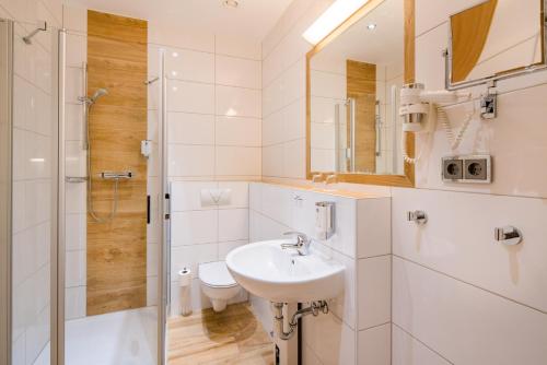 a white bathroom with a sink and a shower at Best Western City Hotel Braunschweig in Braunschweig