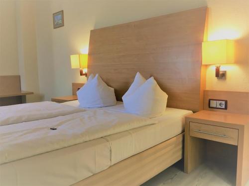 a bedroom with a large bed with two white pillows at Pension Am Pollingpark in Dessau