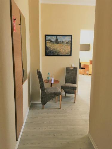 a hallway with chairs and a table in a room at Pension Am Pollingpark in Dessau
