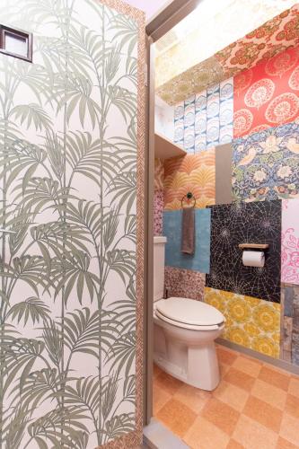 a bathroom with a toilet and a wall mural at Omotenashi House Kawaguchi in Kawaguchi