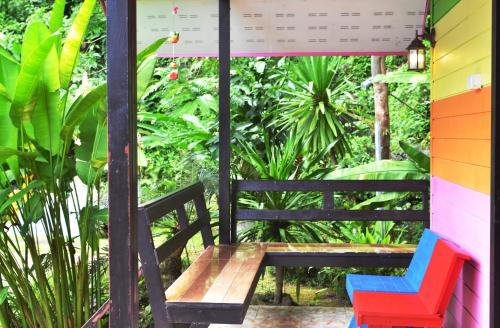 a wooden bench sitting on the porch of a house at Khao Chang View Resort in Phangnga