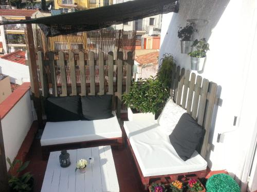 a balcony with two white benches on a building at Hostal La Lluna in Arenys de Mar