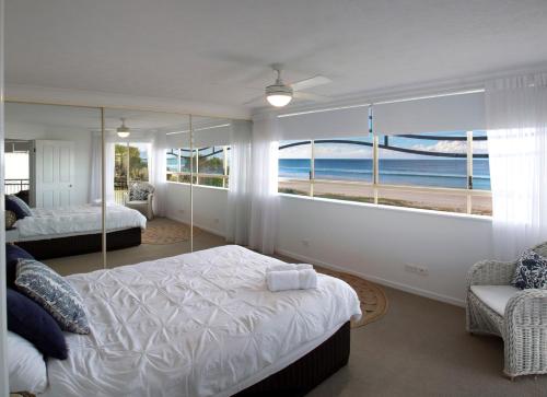 una camera da letto con due letti e vista sull'oceano di Golden Riviera Absolute Beachfront Resort a Gold Coast