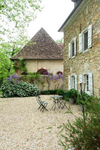 two benches sitting in front of a stone building at Château d’Orion in Orion