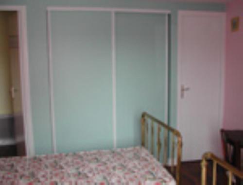 a bedroom with a bed and two tall closets at Gite Ker Maria Gite Ker Louis Piscine in Saint-Gravé
