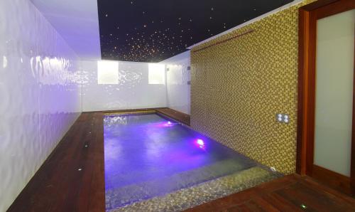 une chambre avec une piscine aux lumières violettes dans l'établissement ViLLA ANNETTE, à Cannes
