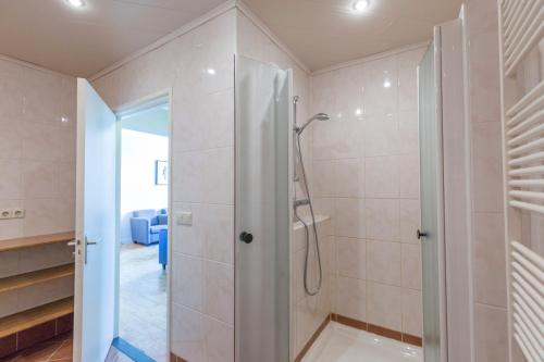 bagno con doccia e porta in vetro di Fletcher Hotel Restaurant Bon Repos a Noorbeek