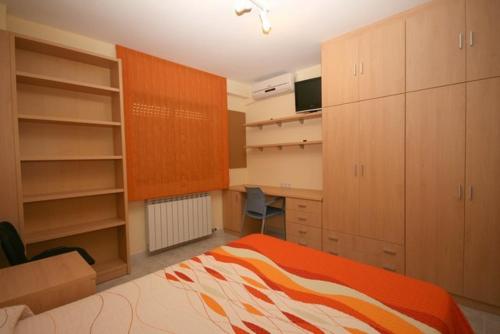 a bedroom with an orange and white bed and cabinets at ApartamentosAlquilerZaragoza in Zaragoza