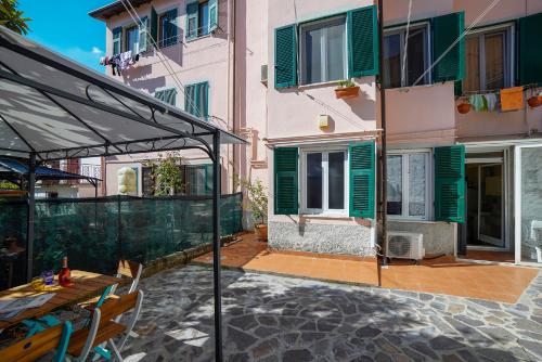 patio ze stołem i parasolem przed budynkiem w obiekcie La Casetta di Pia w mieście La Spezia