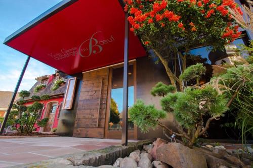 a building with a red umbrella in front of it at Auberge au Boeuf in Sessenheim
