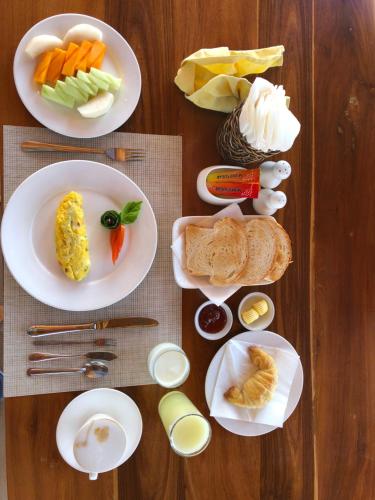 a wooden table with plates of food on it at Inle Cottage Boutique Hotel in Nyaung Shwe