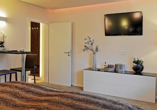 a bedroom with a bed and a table and a television on the wall at Design Apartment nähe Düsseldorf in Krefeld