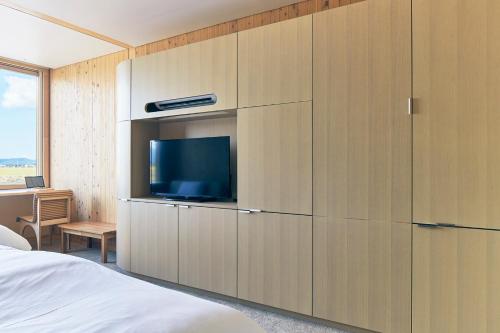 a bedroom with a large wooden cabinet with a tv at Shonai Hotel Suiden Terrasse in Tsuruoka