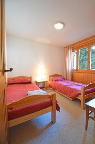 a bedroom with two beds and a table at Centre Etoile 130 in Verbier