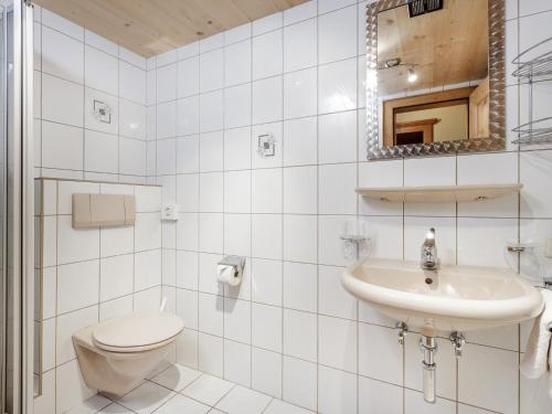 a white bathroom with a toilet and a sink at Apart Gentiana in Sölden