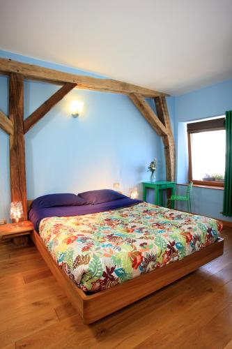 - une chambre avec un lit doté d'un couvre-lit coloré dans l'établissement Maison d'hôtes LES RAINETTES, à Breuillet