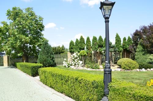 a street light in a garden with a hedge at Zajazd Rycerski in Kozienice