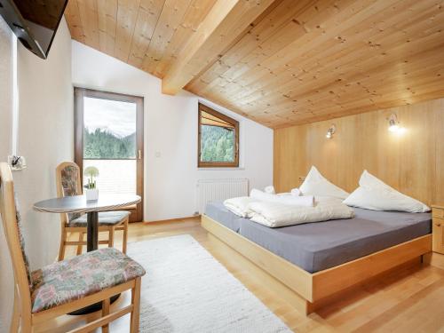 een slaapkamer met een bed, een tafel en een stoel bij Apart Gentiana in Sölden