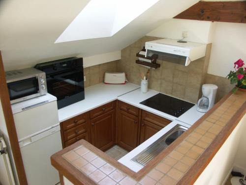 uma pequena cozinha com um fogão e um lavatório em Gite de la Drouette et chambre d'hôtes em Villiers-le-Morhier