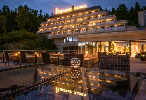 a hotel with a pool in front of a building at Postojna Cave Hotel Jama in Postojna