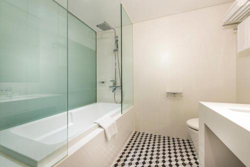 a bathroom with a glass shower and a toilet at Hotel Peyto Samseong in Seoul