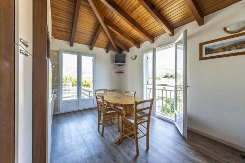 une salle à manger avec une table, des chaises et des fenêtres dans l'établissement Terrasse de Malbeccu, à Casamaccioli