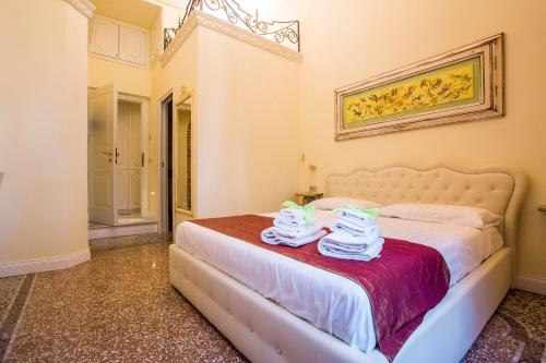 una camera da letto con un letto e asciugamani di Trastevere Royal Suite Trilussa a Roma