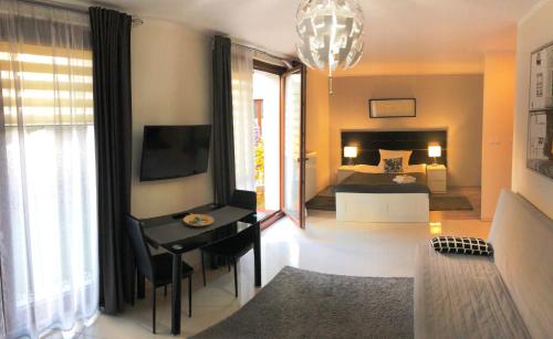 sypialnia z łóżkiem i biurkiem z telewizorem w obiekcie MOKO Apartment w Warszawie
