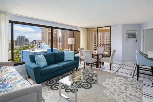 a living room with a blue couch and a view of the city at Waikiki Timeshare 77 in Honolulu