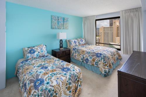 a hotel room with two beds and a window at Waikiki Timeshare 77 in Honolulu