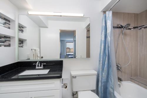 a bathroom with a sink and a toilet and a mirror at Waikiki Timeshare 77 in Honolulu
