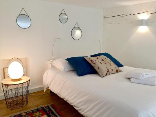- une chambre avec un lit blanc et deux lumières sur le mur dans l'établissement Le Cocon de la Daurade by Cocoonr, à Toulouse