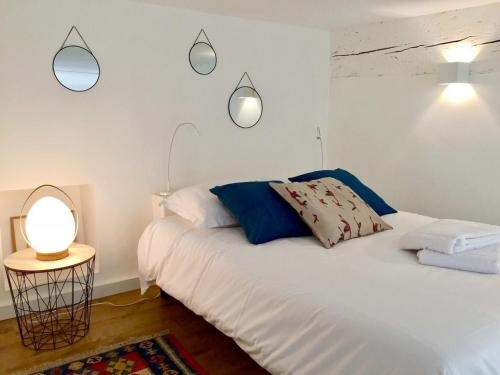 - une chambre avec un lit blanc et deux lumières sur le mur dans l'établissement Le Cocon de la Daurade by Cocoonr, à Toulouse