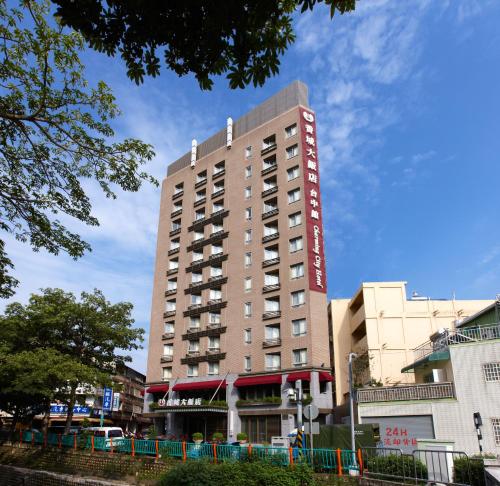 a tall building with a sign on the side of it at Taichung Charming City Hotel in Taichung