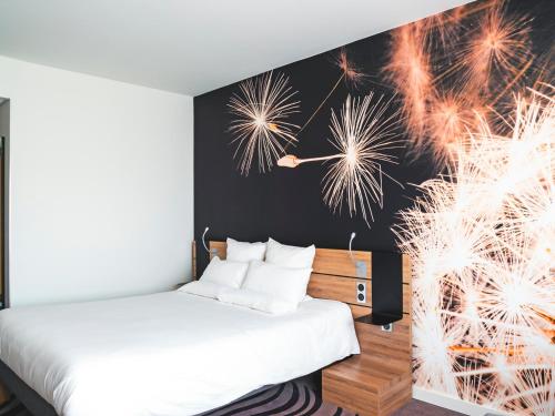 a bedroom with a bed and a wall with fireworks at Novotel Katowice Centrum in Katowice