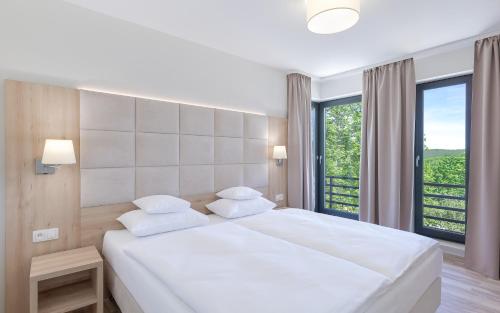 sypialnia z białym łóżkiem i dużym oknem w obiekcie Blue Mountain Resort w Szklarskiej Porębie