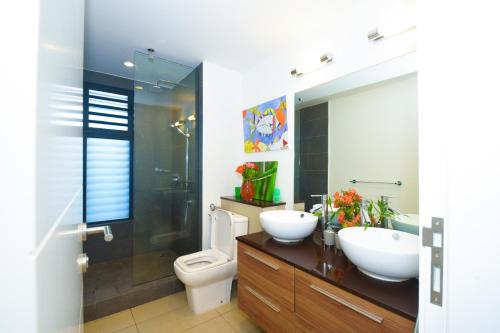 a bathroom with two sinks and a toilet at Azuri Resort -Sea View & Golf Luxury Apartment in Roches Noires